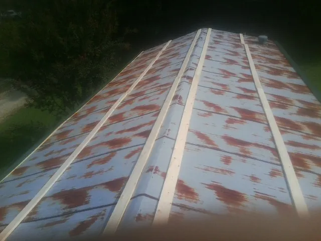 Rusted metal roof panels with new wood purlins before replacement — Storm Damage Roof Repair in Bee Spring by Roofing Brothers